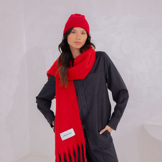 Person wearing a red scarf and hat against a white background