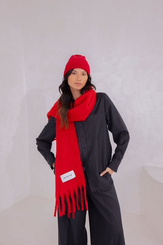 Person wearing a red scarf and hat against a white background