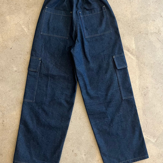 Blue work pants on a beige concrete floor