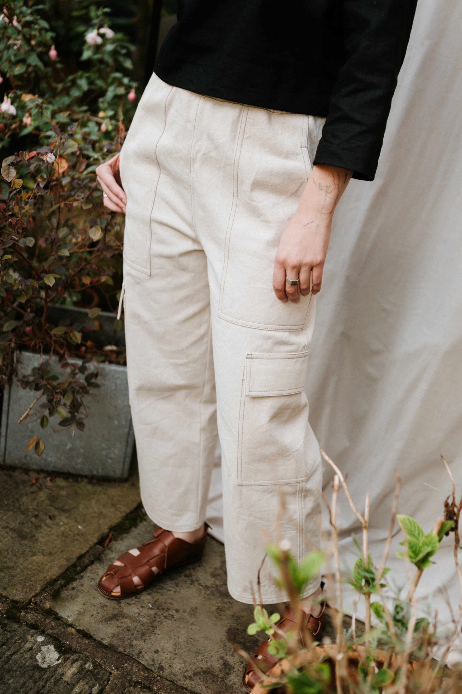 Person wearing beige cargo pants and brown shoes outdoors.