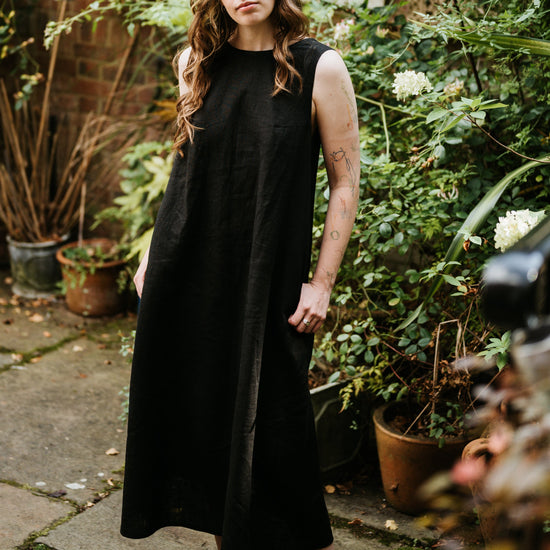 Woman in a black dress standing in a garden setting