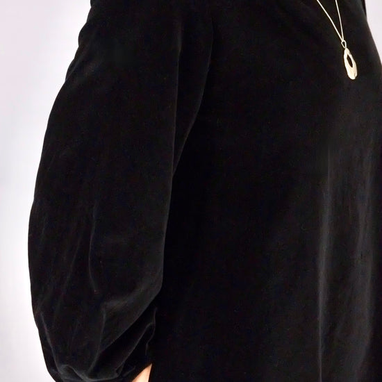 Black velvet dress with puffed sleeves on a white background
