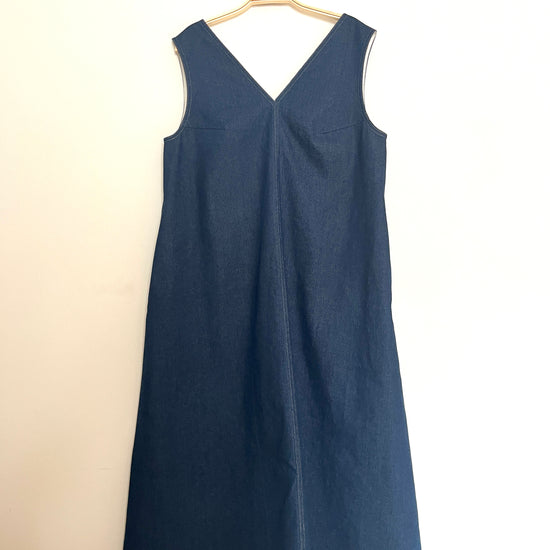 Indigo denim aline sleeveless long dress with a v-neck and centre seam on a cream background