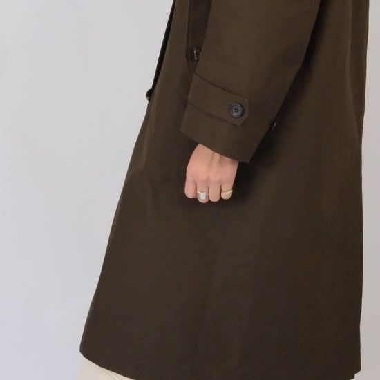 side view of model wearing brown waxed rain coat by atwin the label