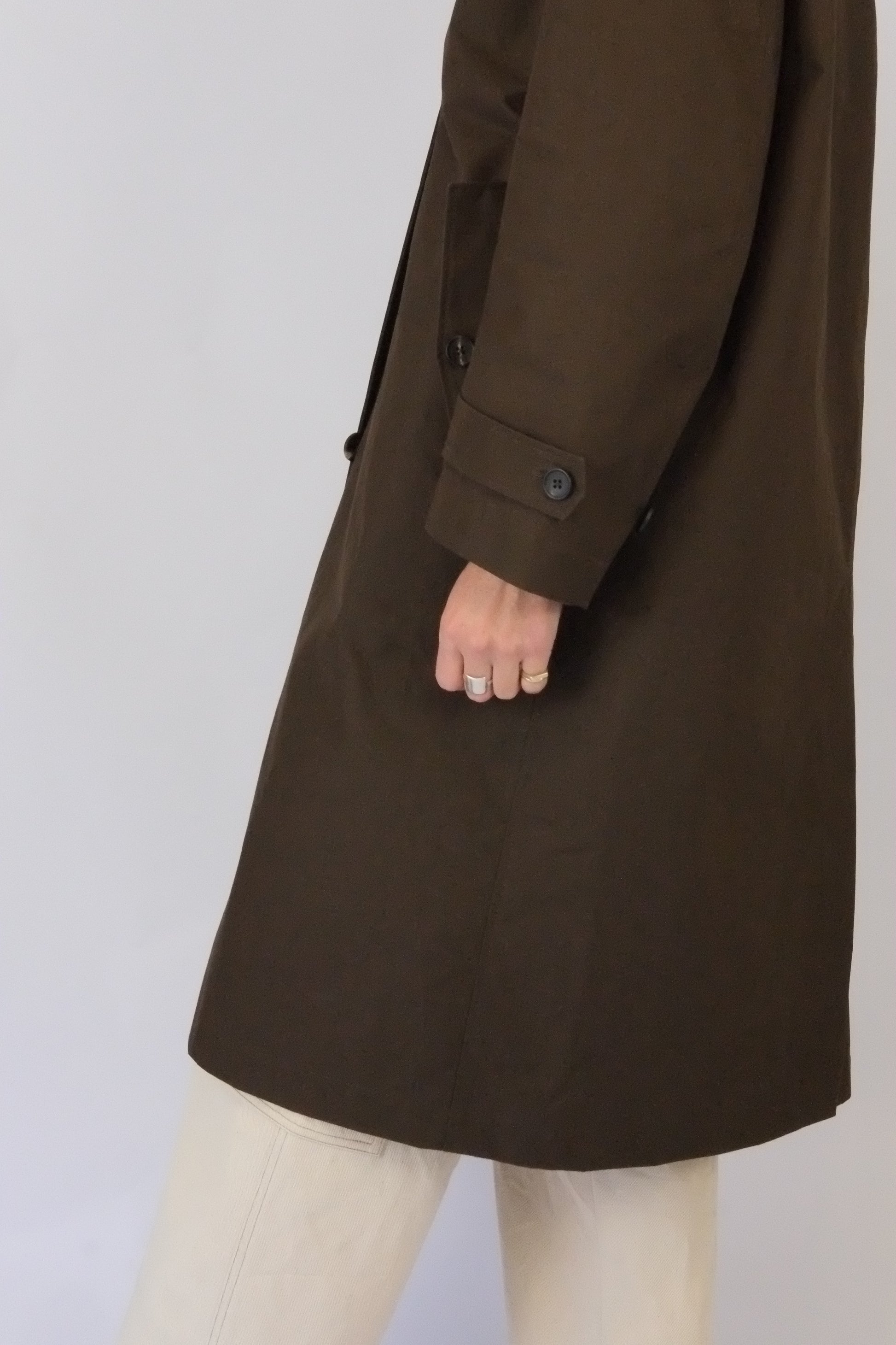 side view of model wearing brown waxed rain coat by atwin the label