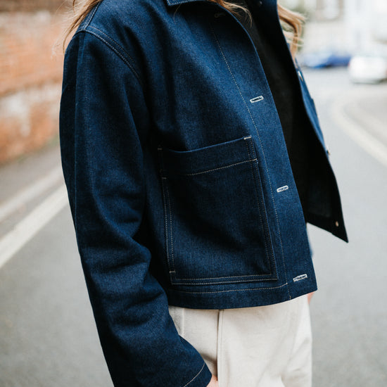Person wearing a blue denim jacket with a blurred background
