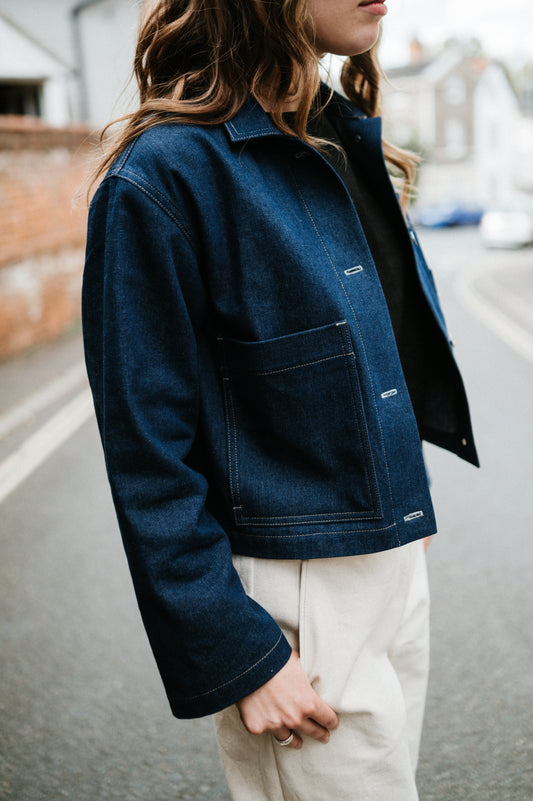 Person wearing a blue denim jacket with a blurred background