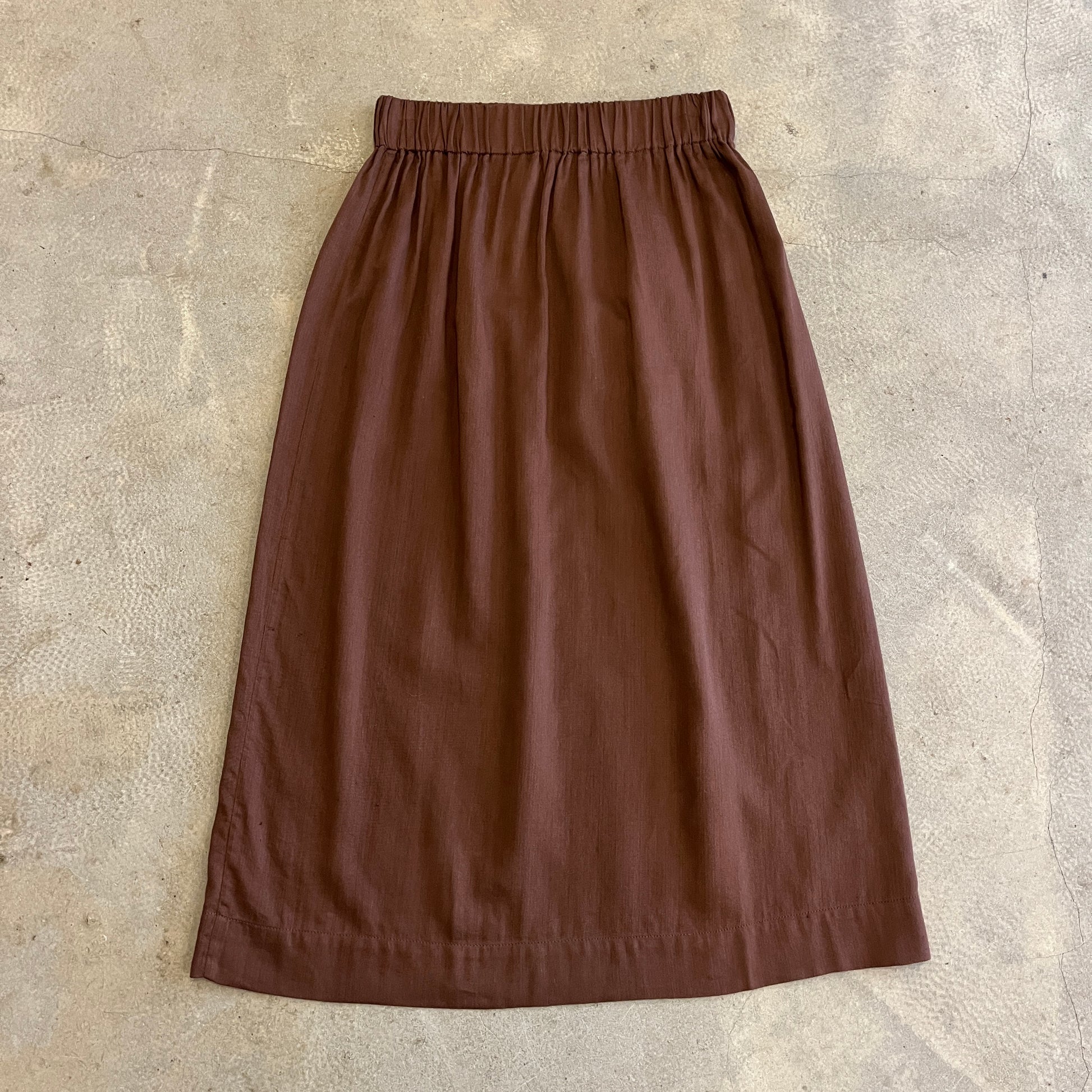 Brown skirt on a textured beige surface