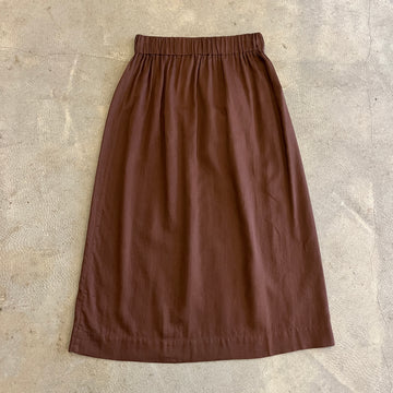 Brown skirt on a textured beige surface