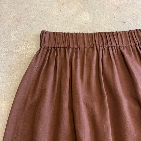 Brown skirt with an elastic waistband on a beige background