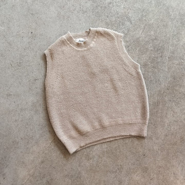 Beige knitted vest on a concrete surface