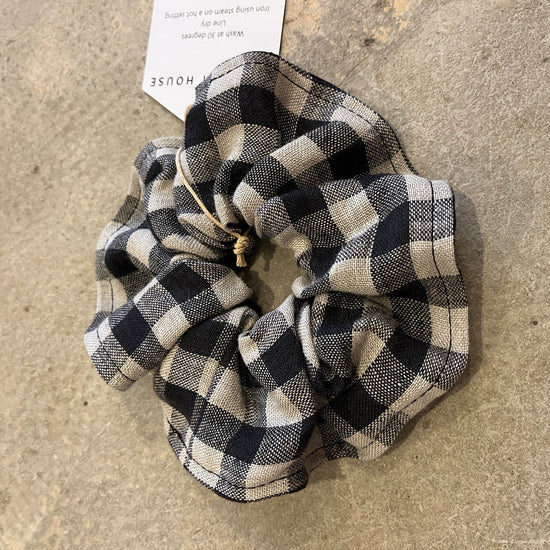 Black and white checkered fabric on a concrete surface with a tag in the background.