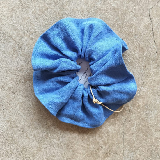 Blue scrunchie on a beige surface