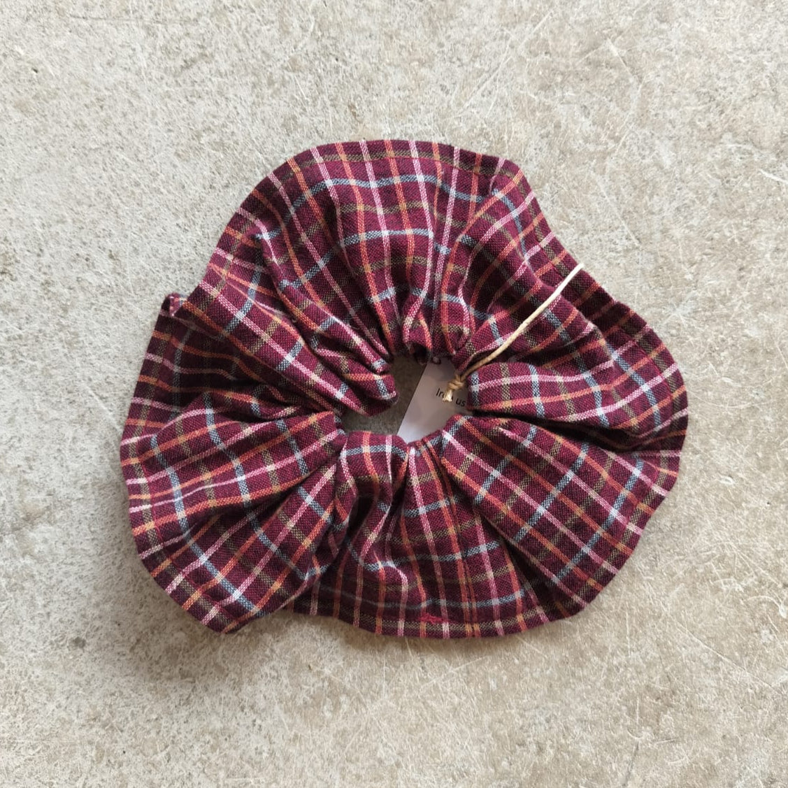 Plaid scrunchie on a beige surface