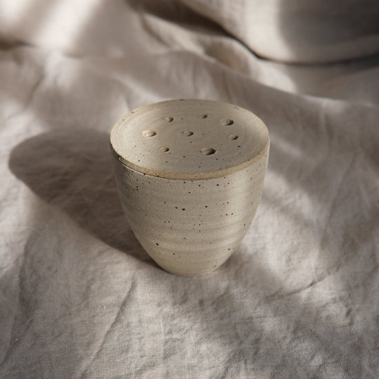 Ceramic pot on a textured fabric surface