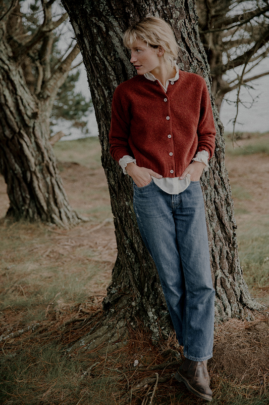 Woman leaning against a tree in a natural setting
