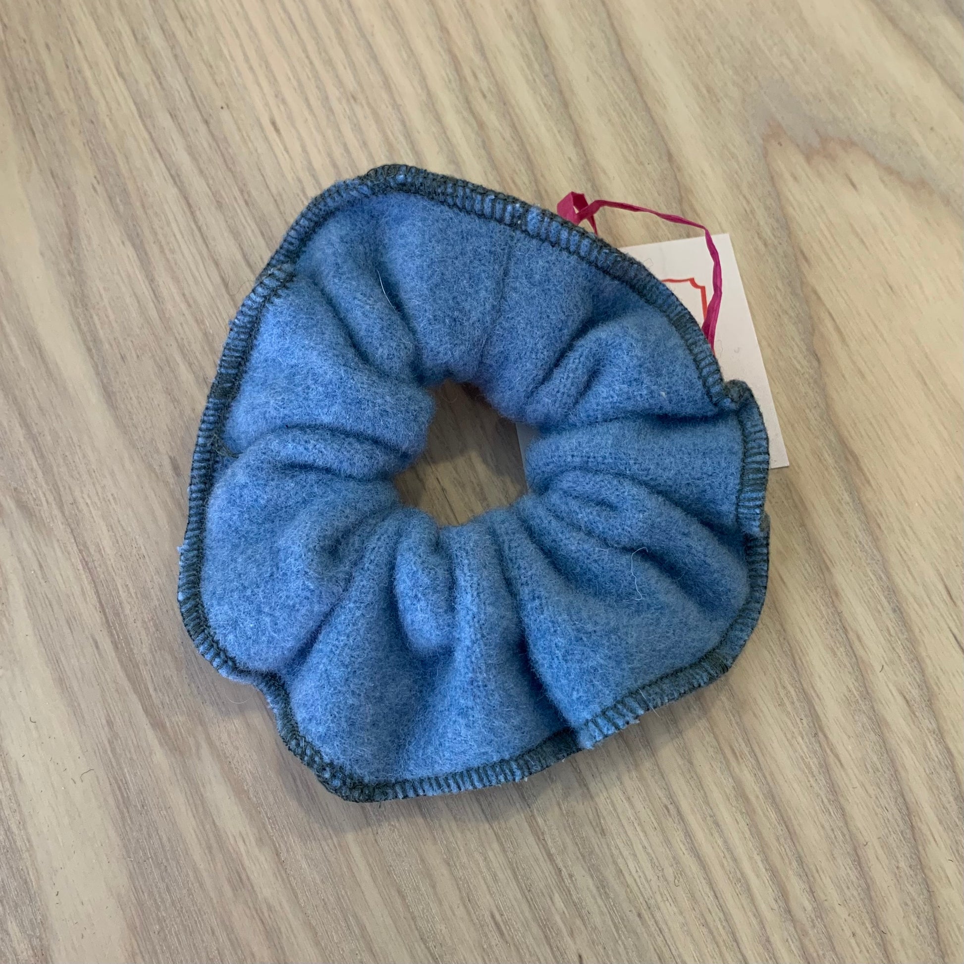 A blue wool scrunchy on a wooden background