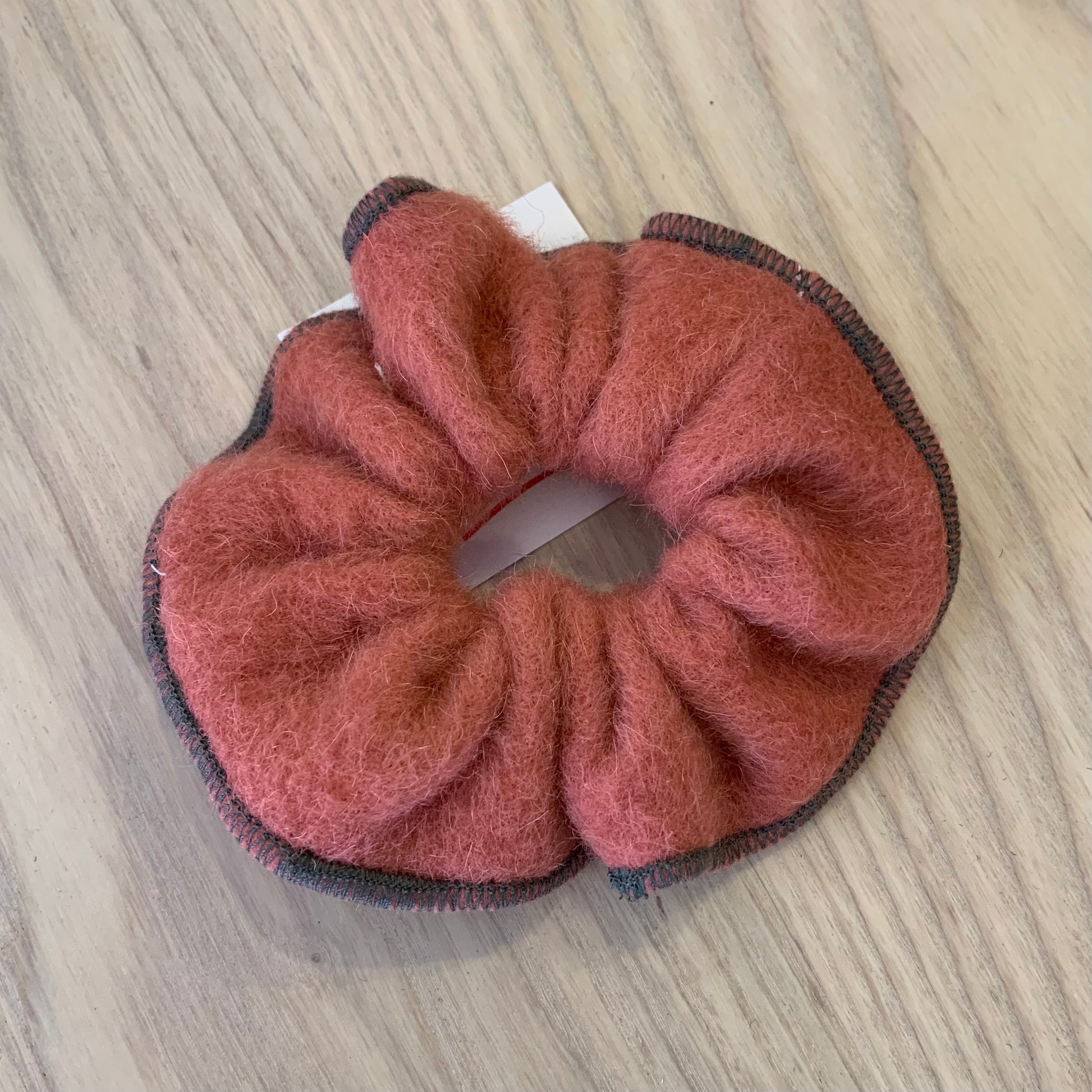 A red wool scrunchie on a wooden background