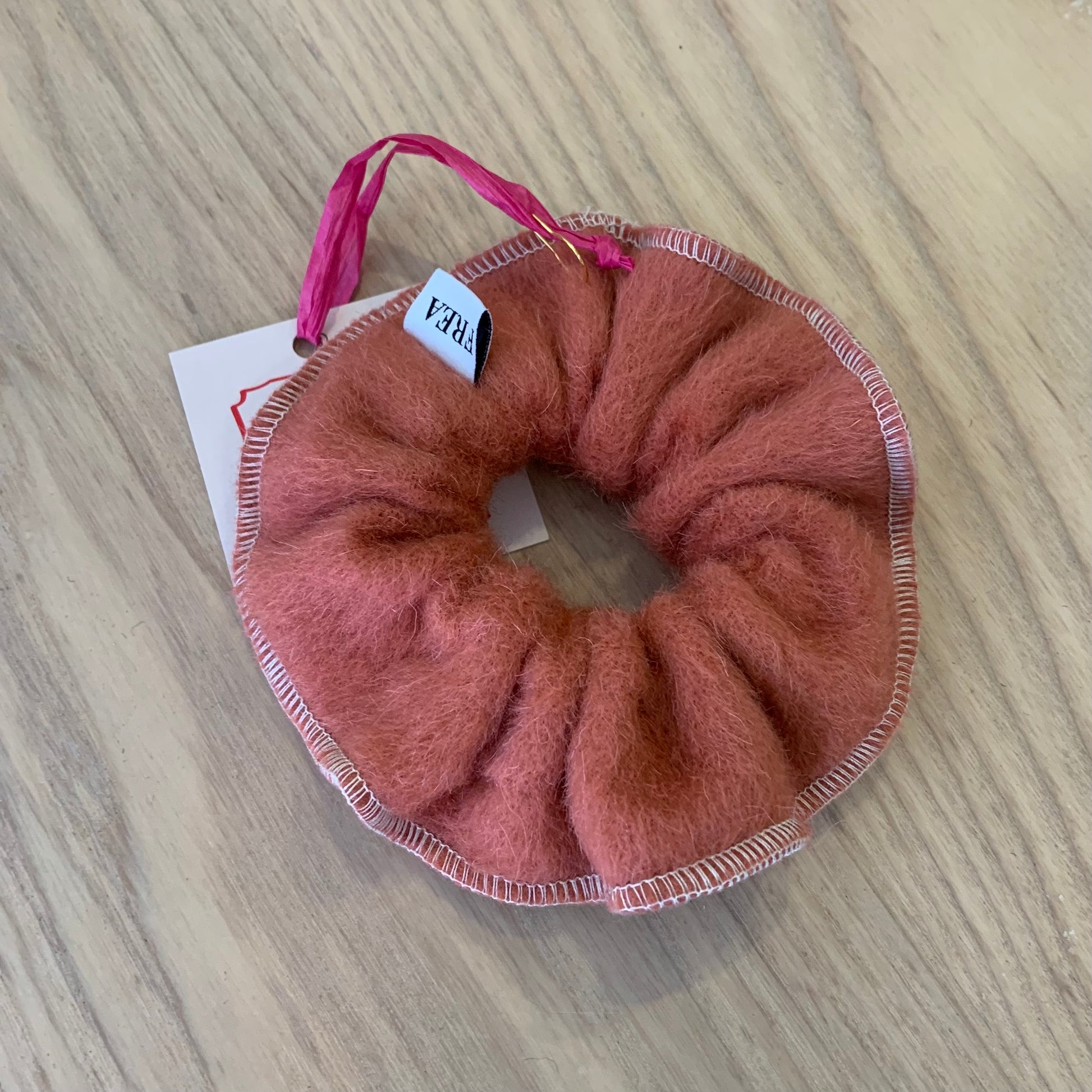 a red wool scrunchy on a wooden background