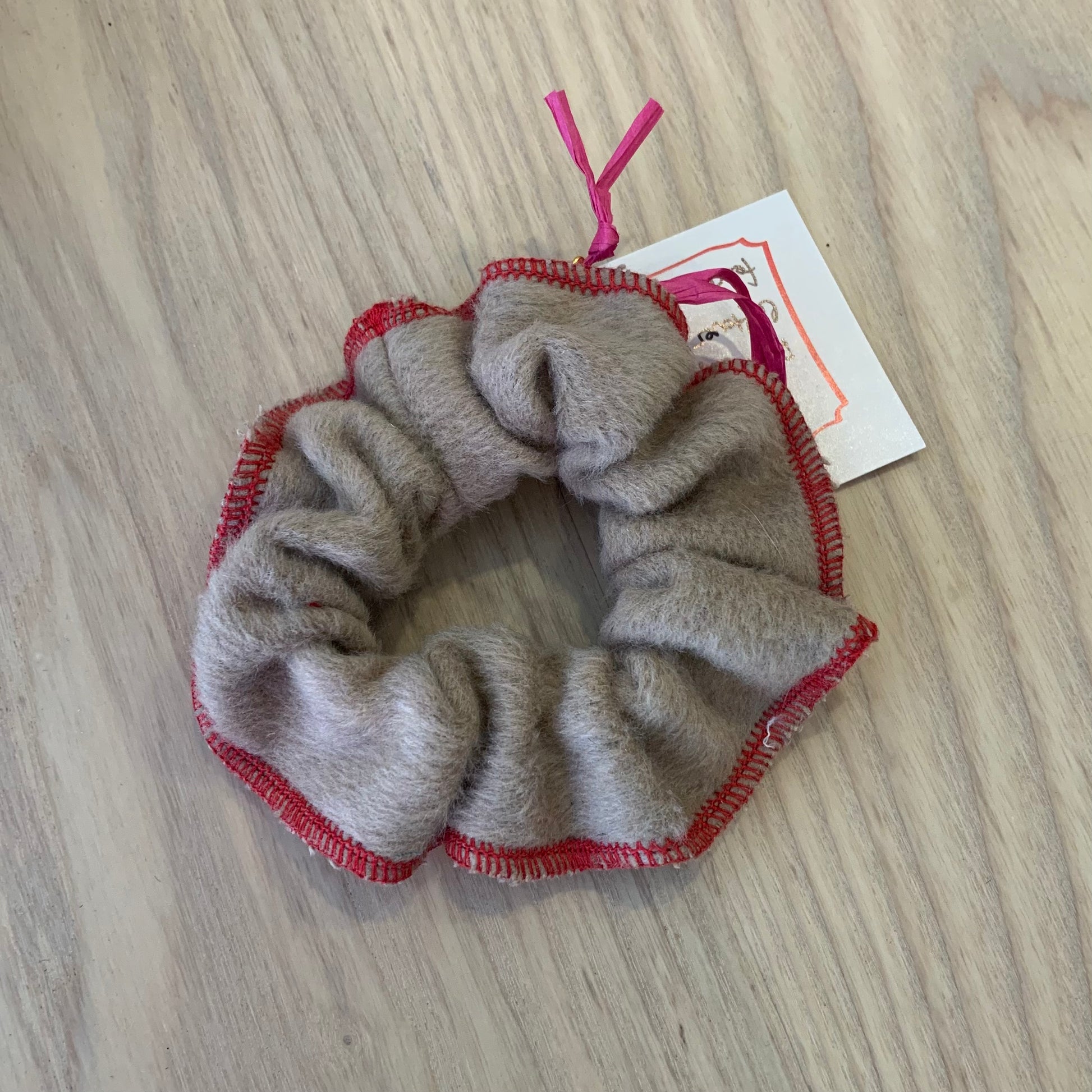 a red and beige wool scrunchy on a wooden background