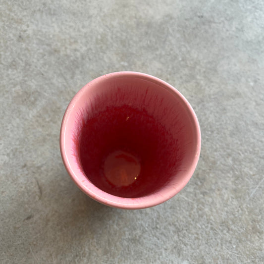 Pink ceramic cup on a gray surface