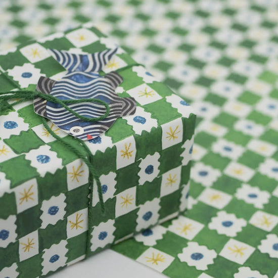 Gift box with decorative paper on a green and white checkered background