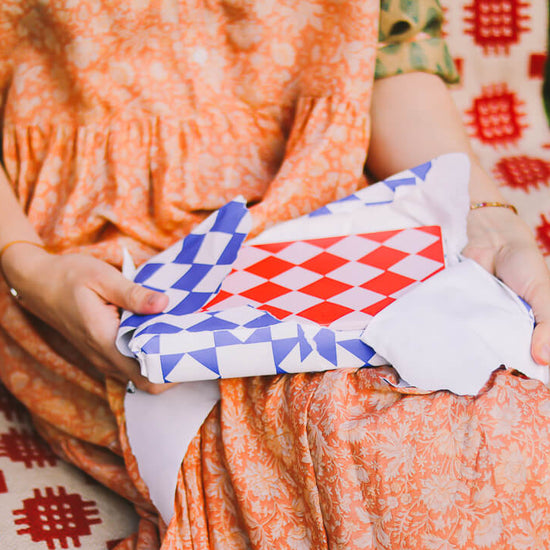 woman opening a pink and red notebook