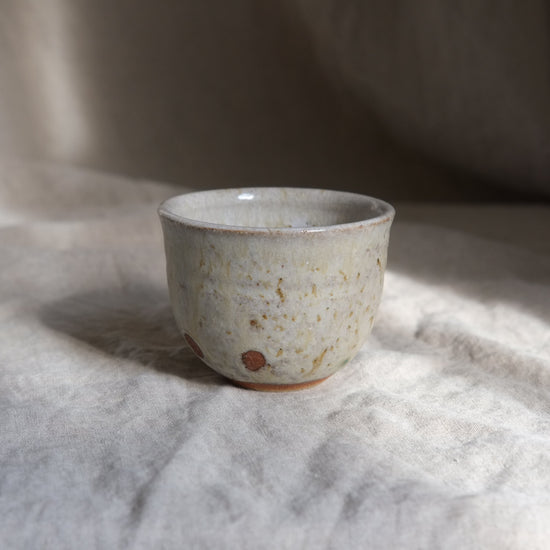 Ceramic cup with textured surface on a light fabric background