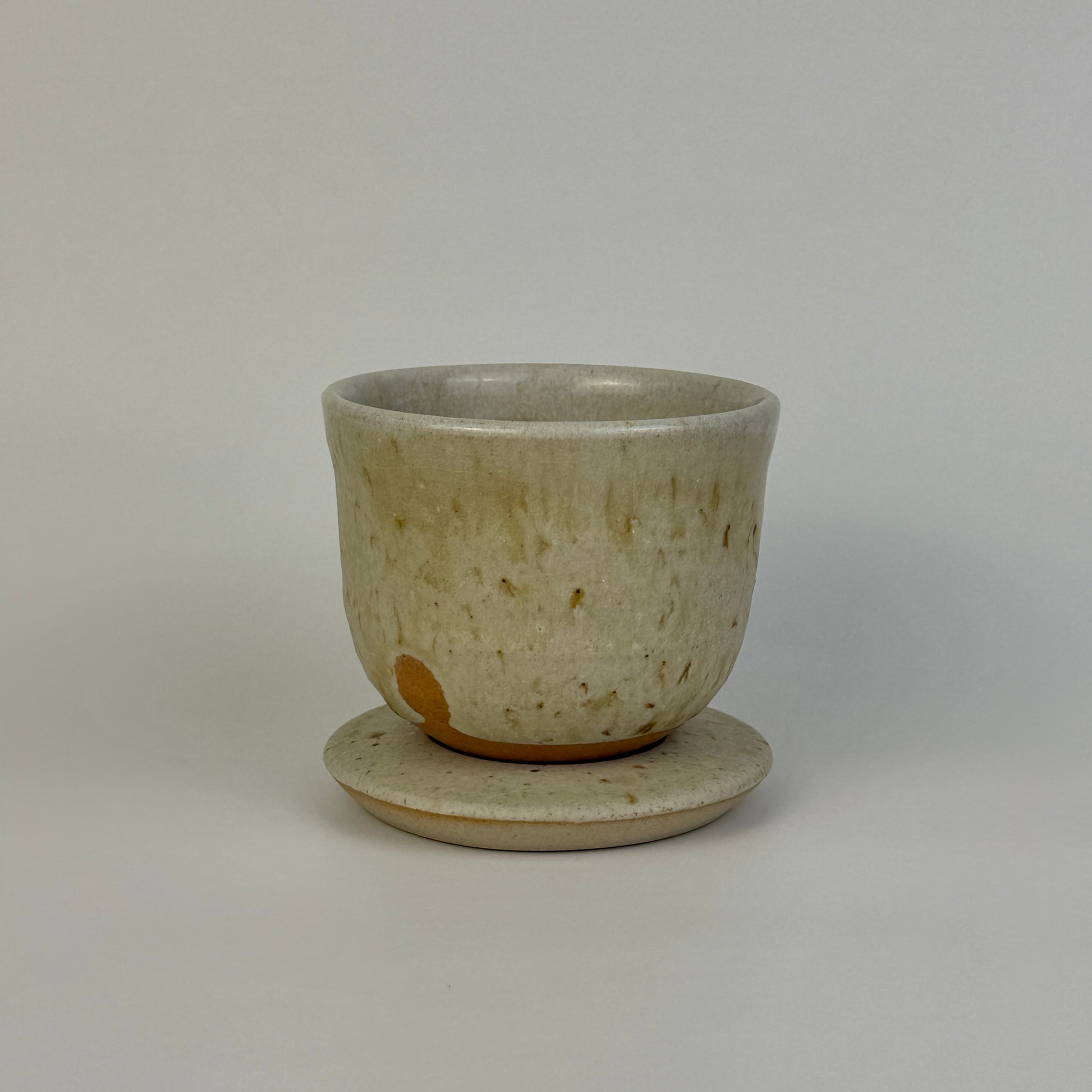 Ceramic cup with saucer on a plain background