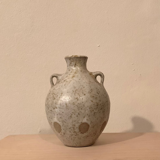 ceramic budvase on a wooden shelf