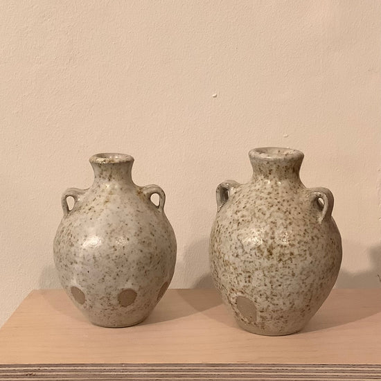 two ceramic budvases on a wooden shelf