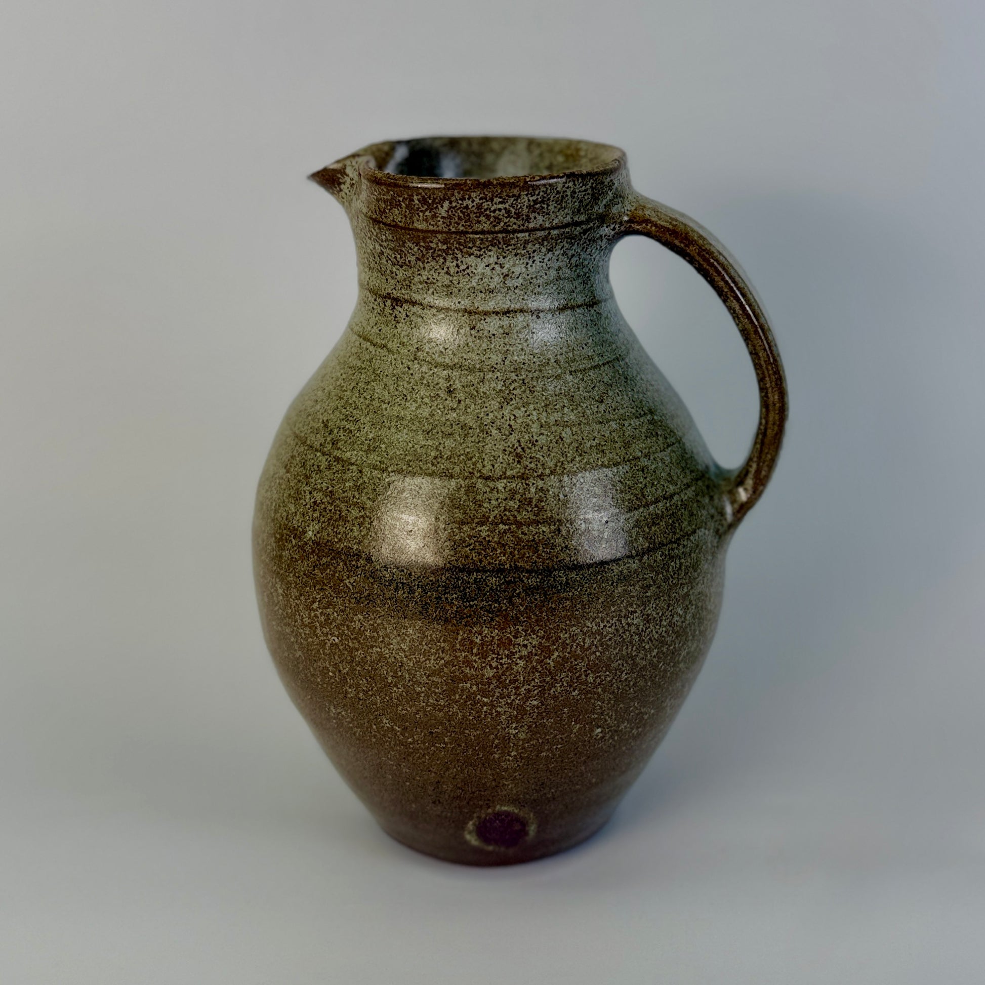 Brown ceramic pitcher on a gray background