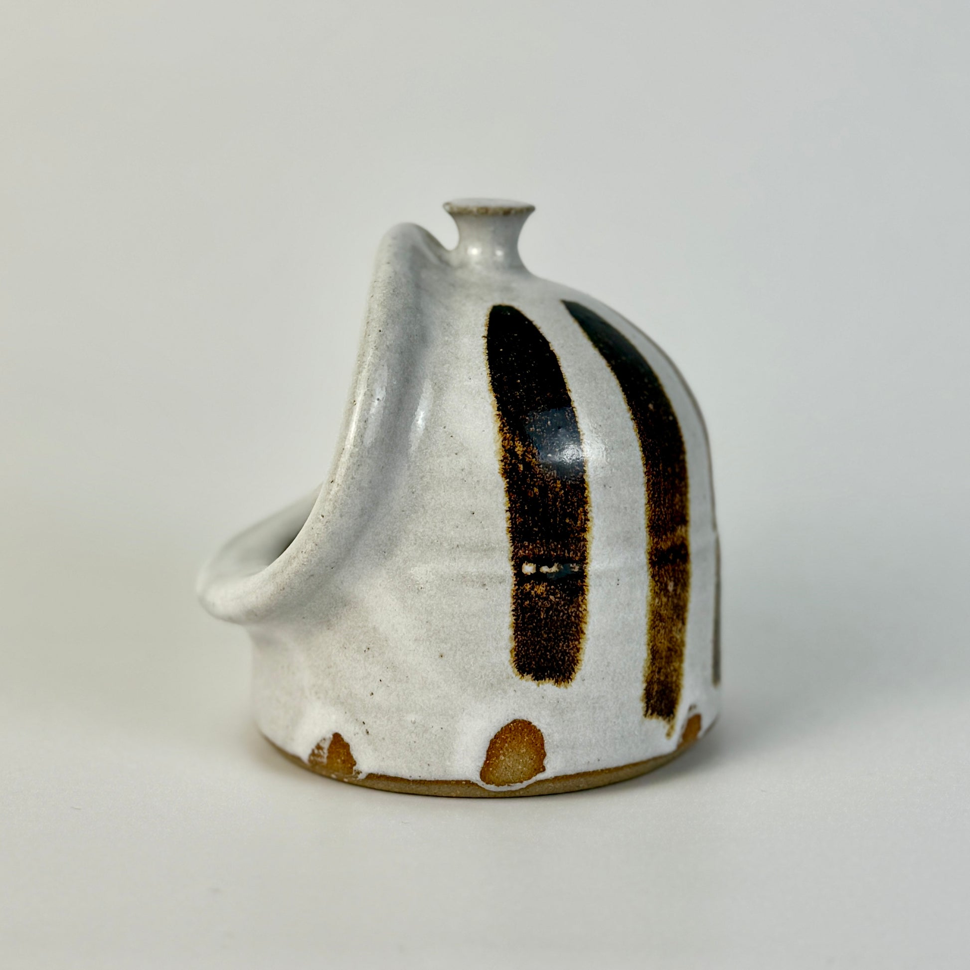 handmade ceramic salt pig with black and brown accents on a light gray background