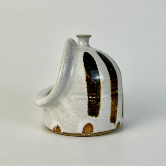 handmade ceramic salt pig with black and brown accents on a light gray background
