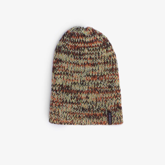 A knitted beanie in warm colours on a white background