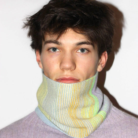 A man wearing a cowl in pale colours