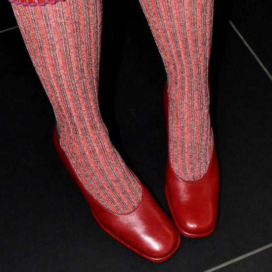 Red and pink socks with red shoes on a black background