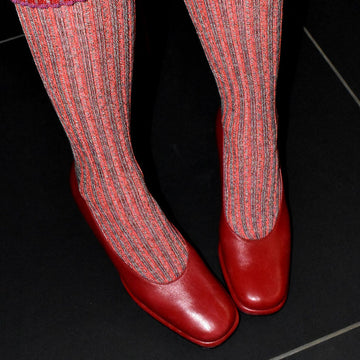 Red and pink socks with red shoes on a black background
