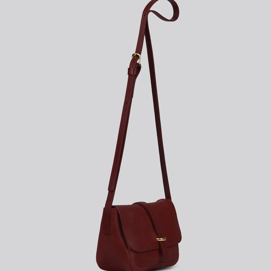 Maroon leather shoulder bag on a light gray background