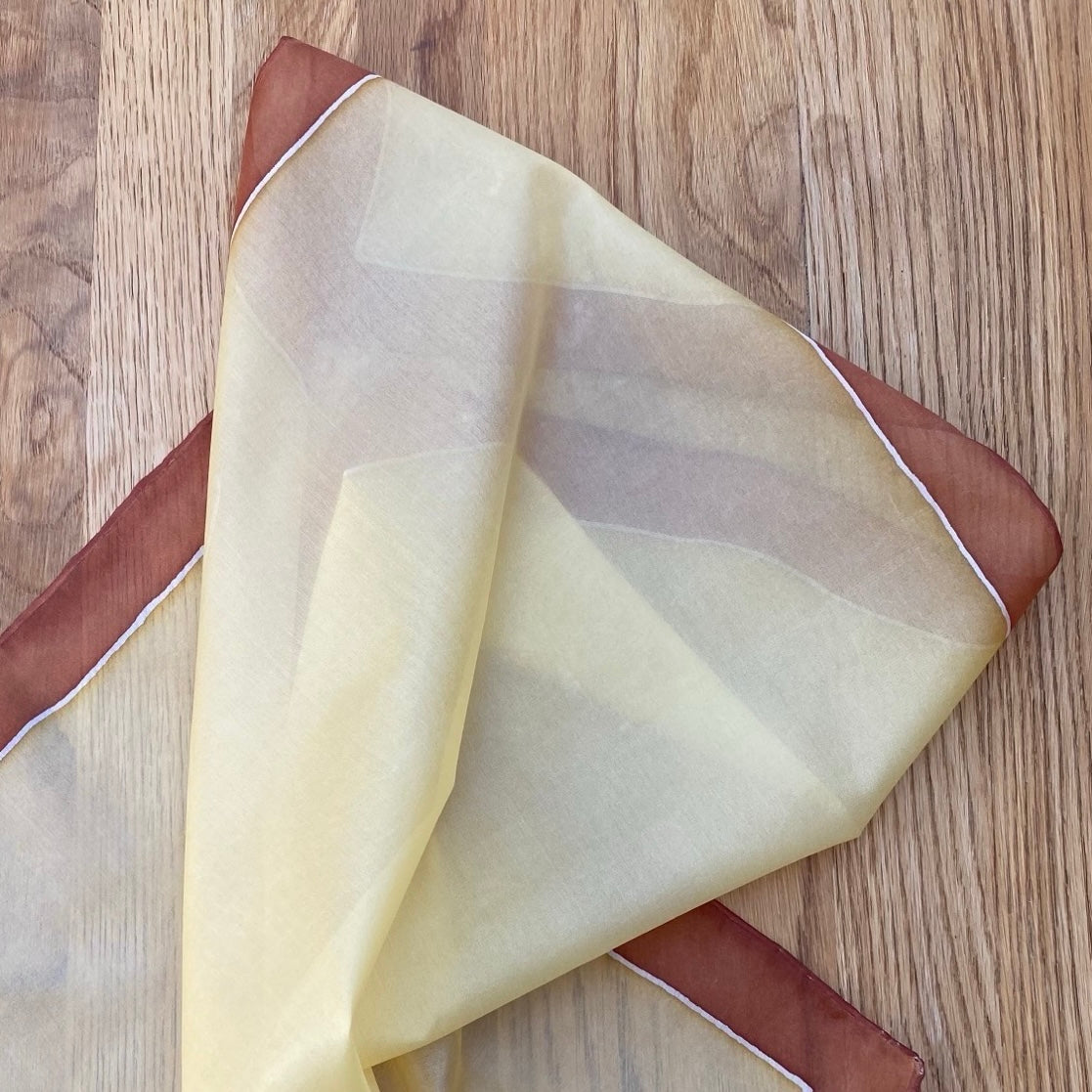 Folded fabric with brown and beige colors on a wooden surface