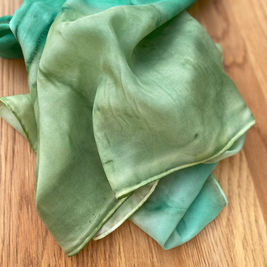 Close up of hand painted green silk scarf