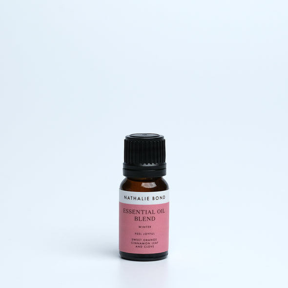 A bottle of Nathalie Bond Essential Oil Winter Blend with visible labeling, set against a plain background.