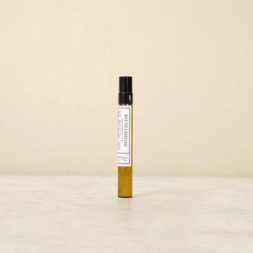 Small perfume bottle with a label on a beige background