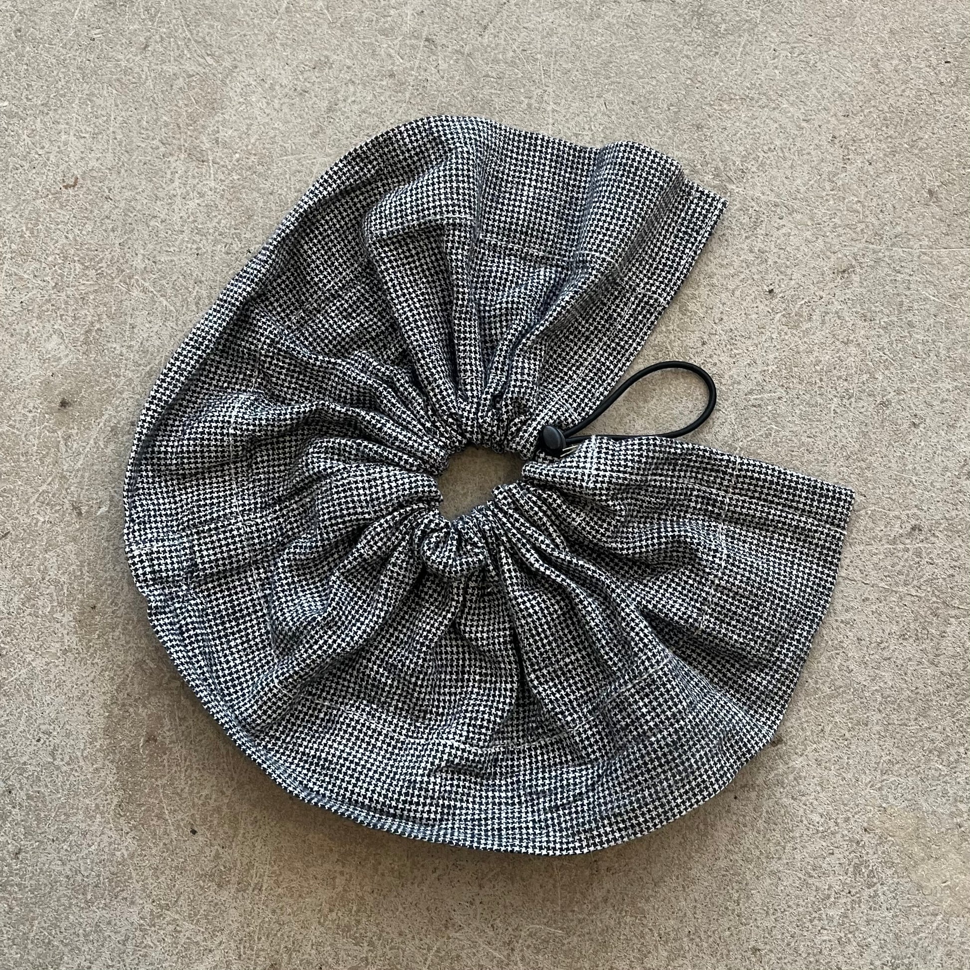 Black and white checkered scrunchie on a beige surface
