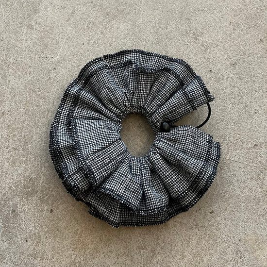 Black and white checkered scrunchie on a beige surface
