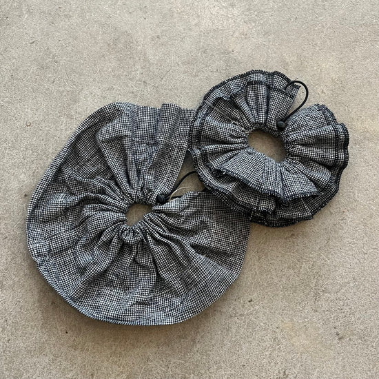 Two black and white checkered fabric drawstrings on a beige surface