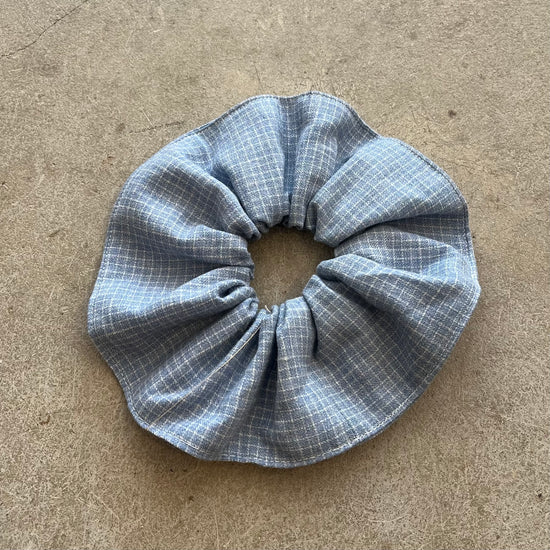 Blue checkered scrunchie on a beige surface