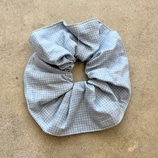Blue checkered scrunchie on a beige surface