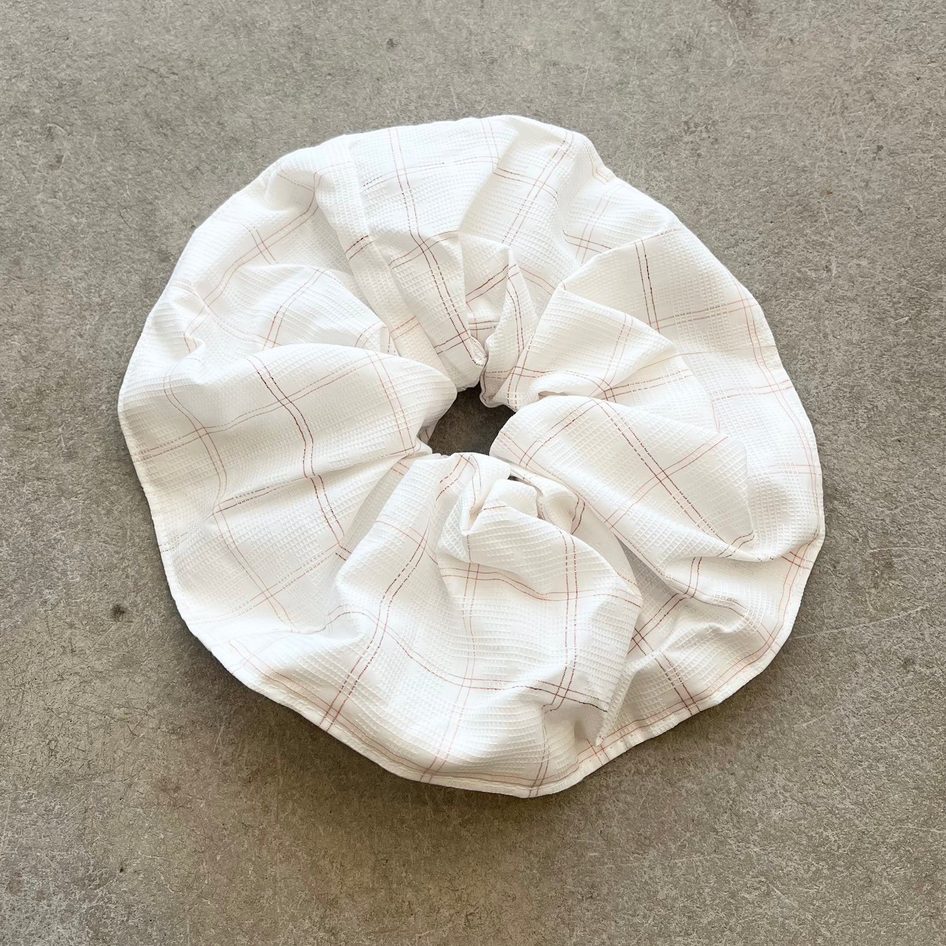 White checkered scrunchie on a gray surface