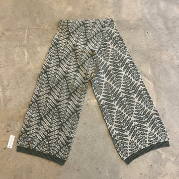 Fern pattern ivory and green scarf on a concrete background